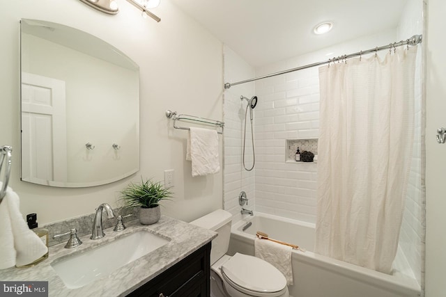 bathroom featuring toilet, shower / bath combo with shower curtain, and vanity