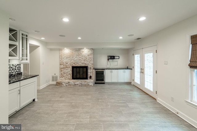 unfurnished living room featuring recessed lighting, visible vents, wine cooler, and baseboards