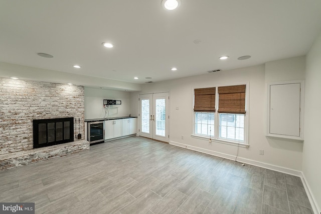 unfurnished living room with recessed lighting, a fireplace, visible vents, and baseboards