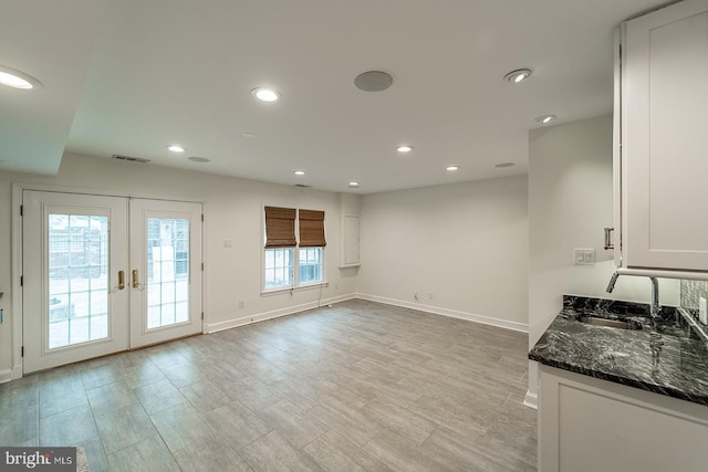 interior space featuring visible vents, baseboards, recessed lighting, french doors, and light wood-type flooring