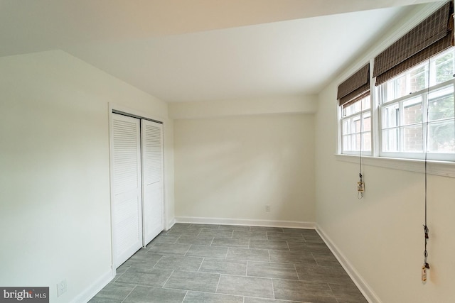 unfurnished bedroom with a closet and baseboards