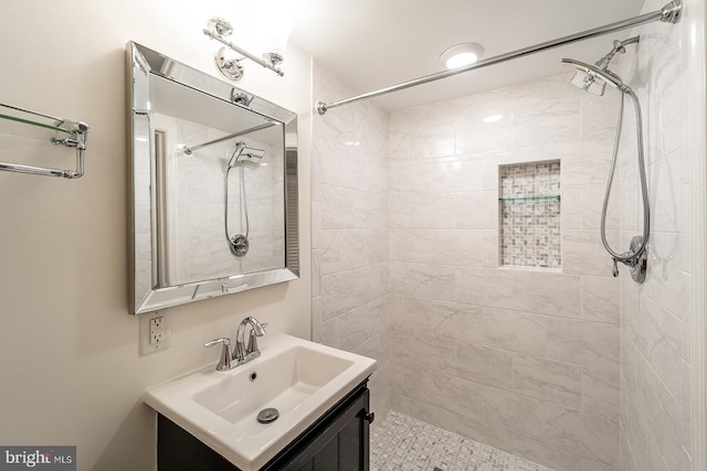 bathroom featuring a tile shower and vanity