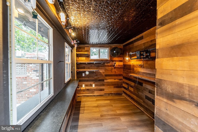 interior space featuring wood walls, an ornate ceiling, and wood finished floors