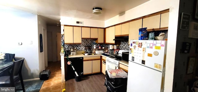 kitchen featuring visible vents, freestanding refrigerator, decorative backsplash, light countertops, and under cabinet range hood