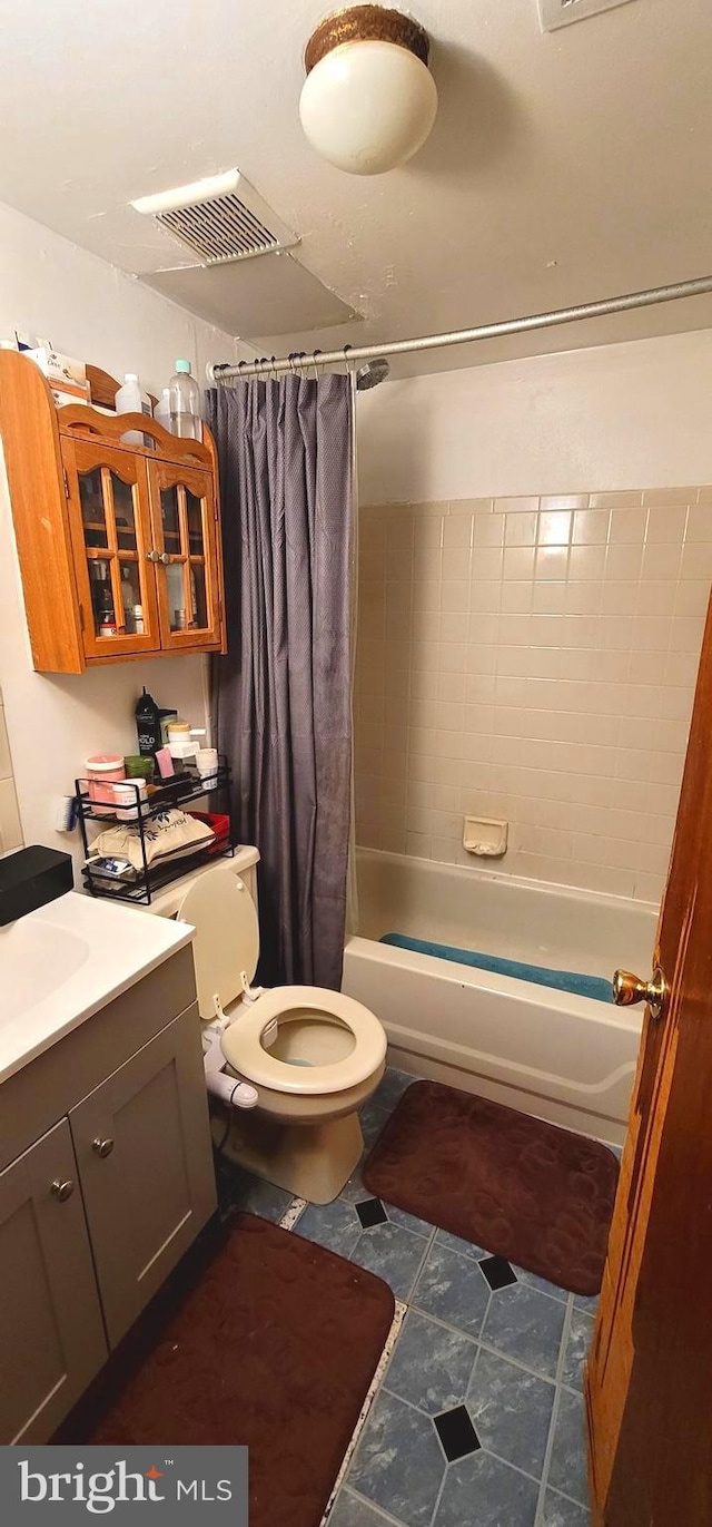 full bath featuring visible vents, shower / bath combo with shower curtain, toilet, and vanity