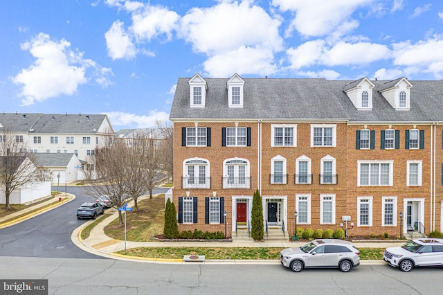 townhome / multi-family property with brick siding and a residential view