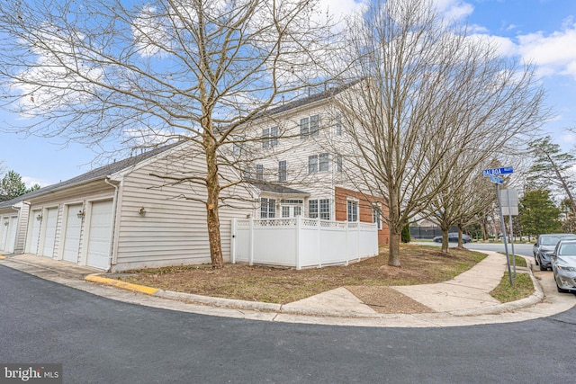 view of front of home with a detached garage and fence