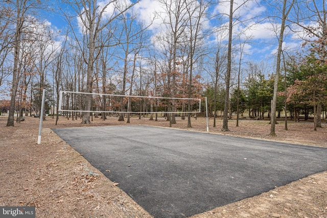 view of property's community with aphalt driveway and volleyball court