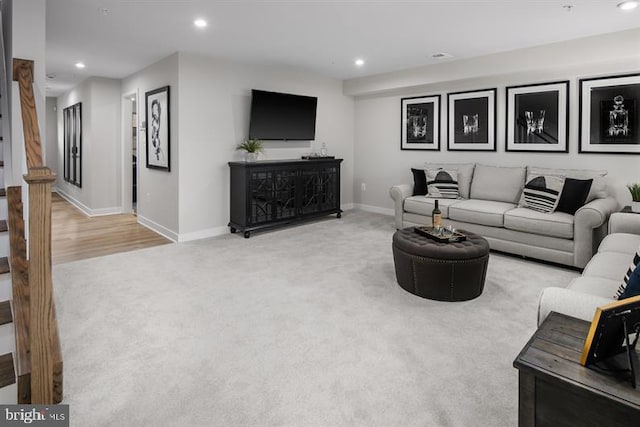 carpeted living area featuring recessed lighting, stairs, and baseboards