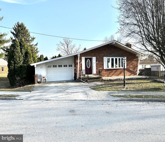 view of front of property featuring a garage, brick siding, concrete driveway, and a chimney