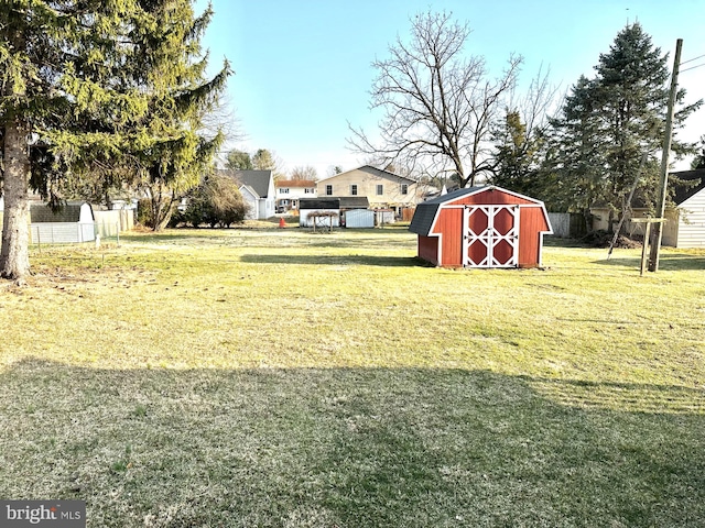 view of yard with a storage shed, an outdoor structure, and fence