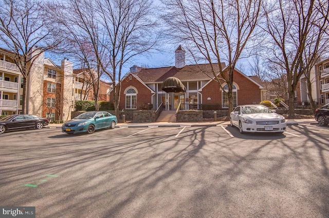 view of front of house featuring uncovered parking and brick siding