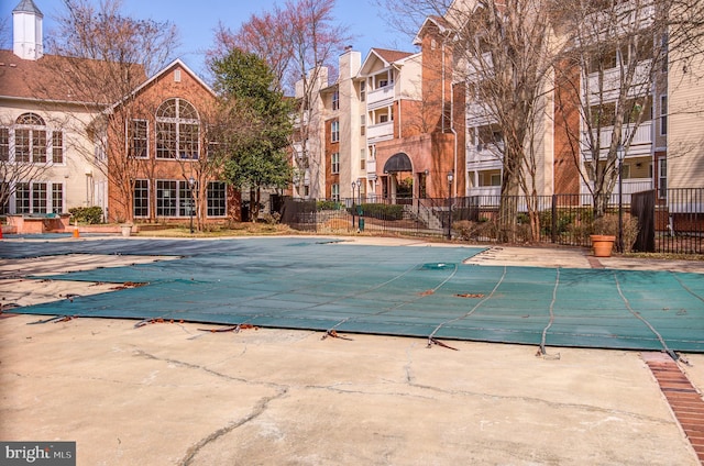 community pool with a patio and fence