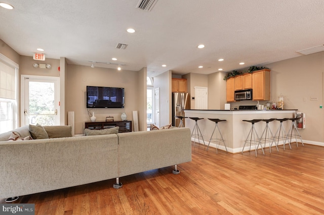 living area featuring visible vents and light wood-type flooring