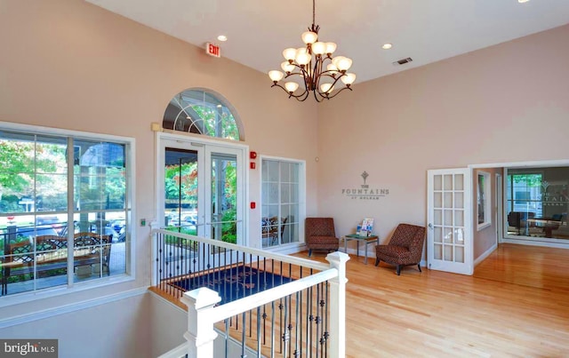 interior space with visible vents, a notable chandelier, and french doors