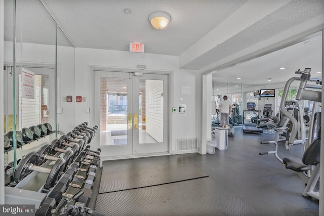 exercise room with visible vents, a textured ceiling, and french doors