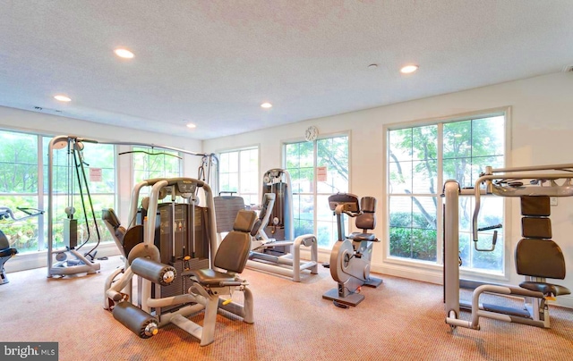 workout area with carpet flooring, recessed lighting, visible vents, and a textured ceiling