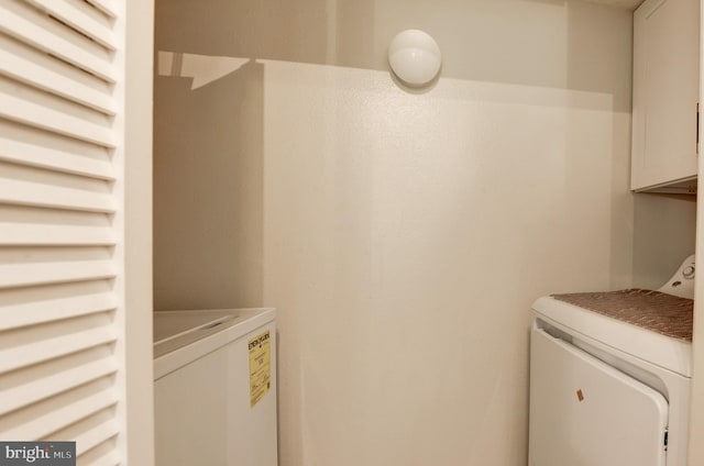 washroom featuring cabinet space and washing machine and dryer