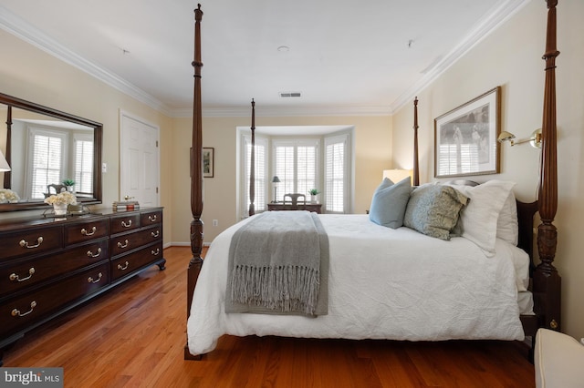bedroom featuring crown molding, visible vents, and light wood-style floors