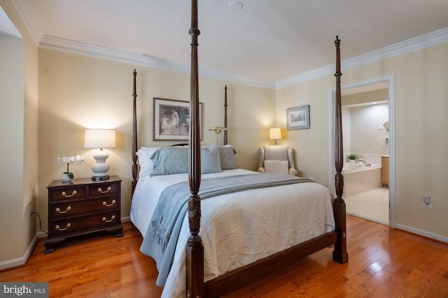 bedroom featuring crown molding, baseboards, wood finished floors, and connected bathroom