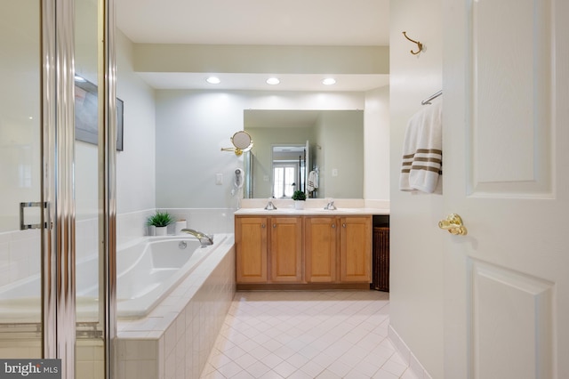 full bathroom featuring double vanity, a sink, tile patterned flooring, and a garden tub