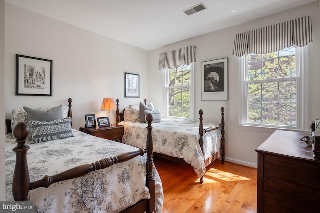 bedroom with baseboards, visible vents, and light wood-style flooring