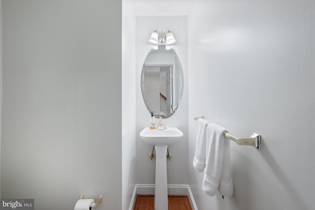 bathroom featuring baseboards, a sink, and wood finished floors