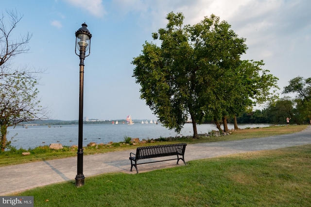 view of property's community with a water view and a yard