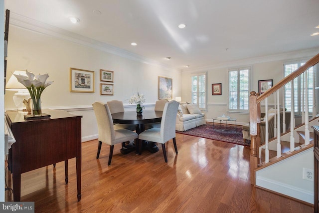 dining room with ornamental molding, wood finished floors, baseboards, stairway, and recessed lighting