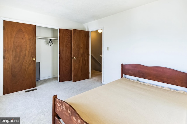 carpeted bedroom featuring a closet and visible vents