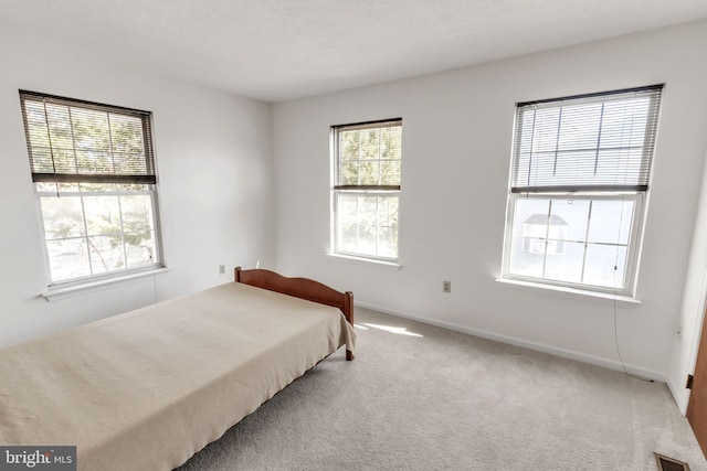 carpeted bedroom featuring visible vents and baseboards