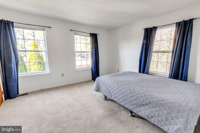 carpeted bedroom featuring visible vents