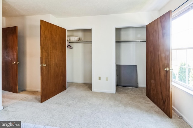 carpeted bedroom with baseboards and multiple closets