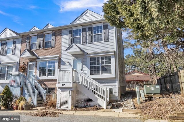 view of front of home featuring fence and brick siding