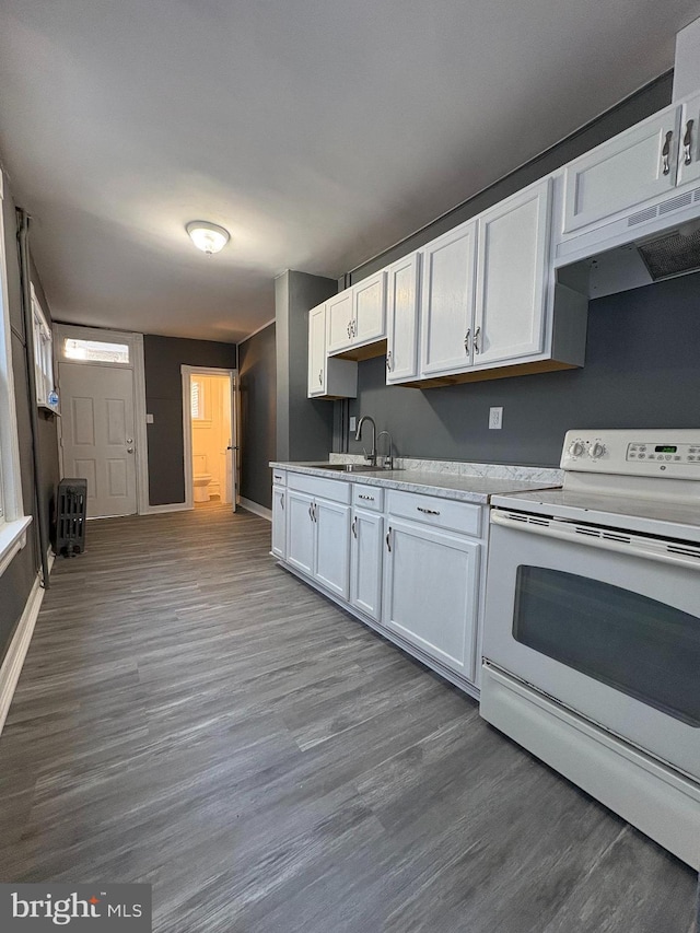 kitchen featuring white electric range, under cabinet range hood, a sink, white cabinetry, and light countertops