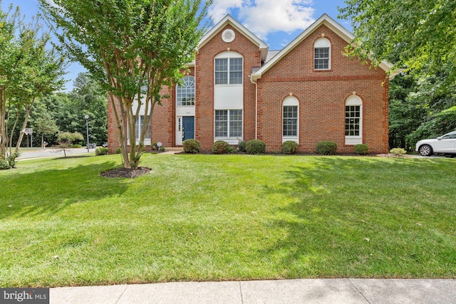 view of front of home with brick siding and a front yard