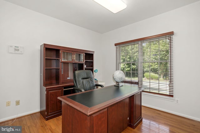 office area featuring baseboards and light wood-type flooring