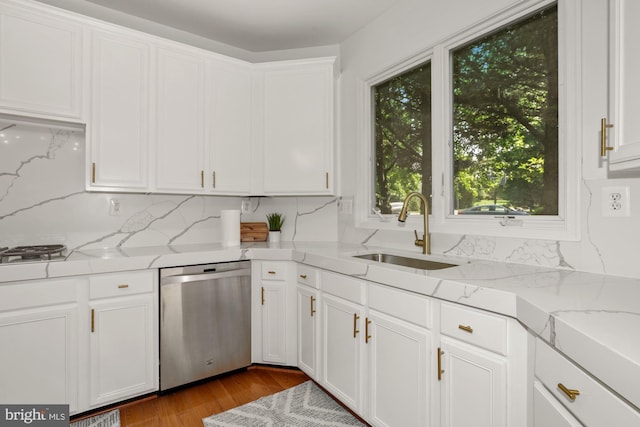 kitchen with gas cooktop, wood finished floors, white cabinetry, a sink, and stainless steel dishwasher