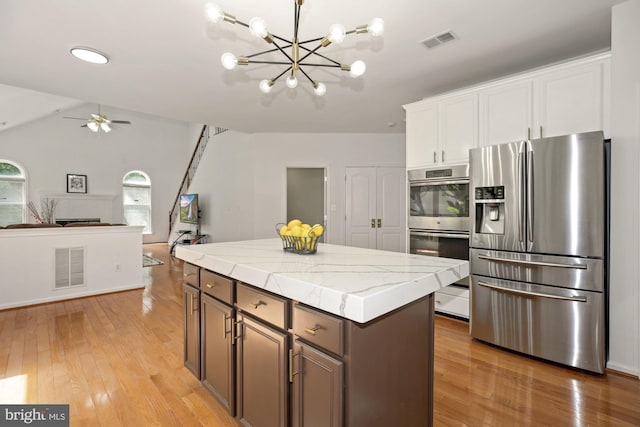 kitchen with visible vents, appliances with stainless steel finishes, a center island, and open floor plan