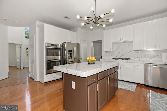 kitchen featuring backsplash, white cabinets, and appliances with stainless steel finishes