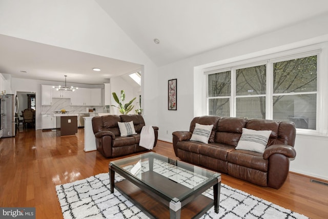 living room with dark wood finished floors, visible vents, a chandelier, and baseboards