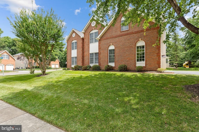 view of front of property with brick siding and a front yard