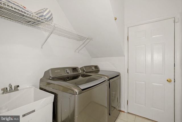 laundry room featuring a sink, separate washer and dryer, light tile patterned flooring, and laundry area