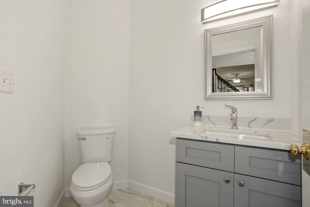 bathroom featuring marble finish floor, toilet, vanity, and baseboards