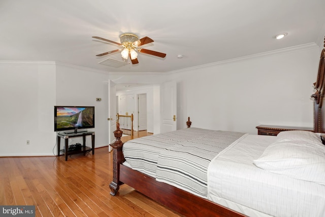 bedroom featuring light wood-type flooring, a ceiling fan, and crown molding