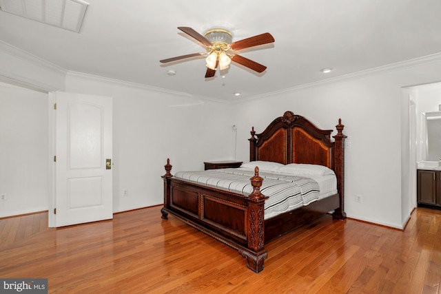 bedroom with visible vents, baseboards, crown molding, and light wood finished floors