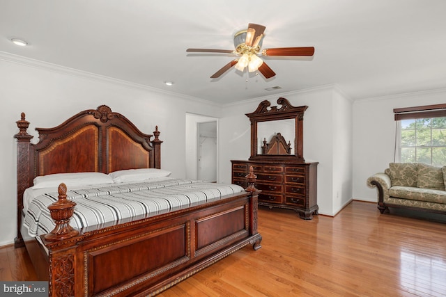 bedroom featuring visible vents, light wood-style flooring, and crown molding