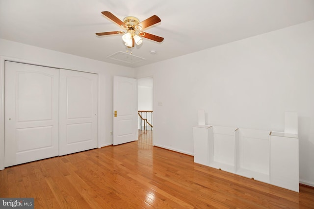 unfurnished bedroom featuring baseboards, light wood-type flooring, a closet, and ceiling fan