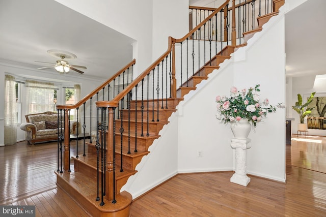 staircase featuring hardwood / wood-style floors, baseboards, and ornamental molding