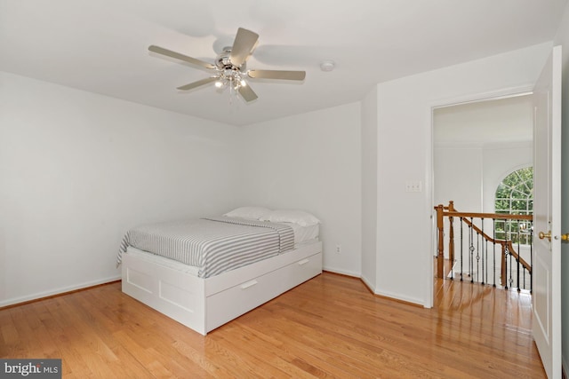 unfurnished bedroom featuring baseboards, wood finished floors, and a ceiling fan